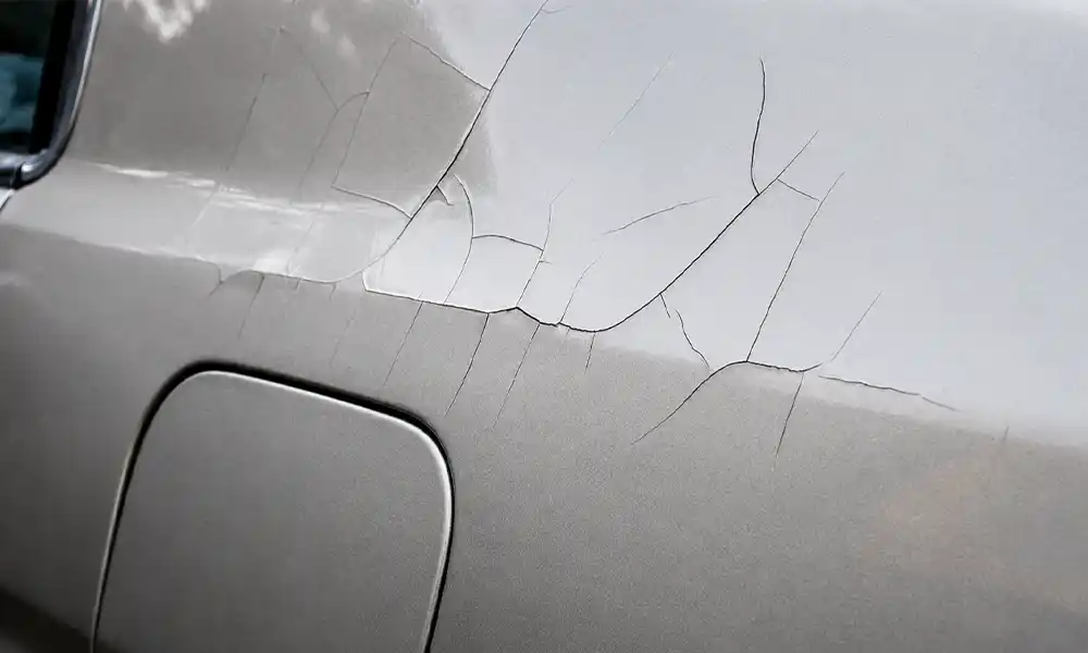 DIY dent removal gone wrong with paint cracking and outward bulge